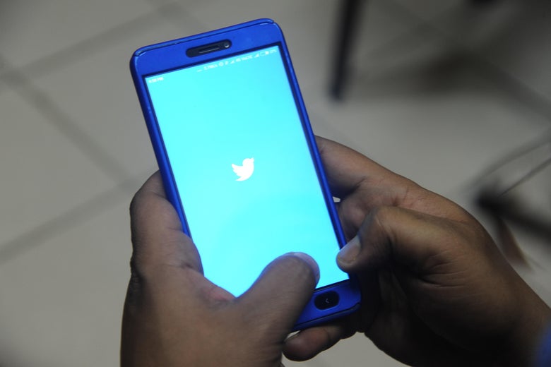 A phone using Twitter is held in a man’s hands.